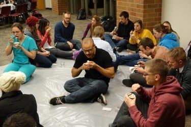 Students eat cooked rice from paper cups to experience life in poverty.